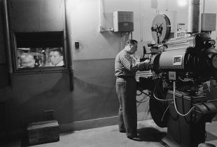 800px-Man_working_with_a_projector_in_a_movie_theater_1958